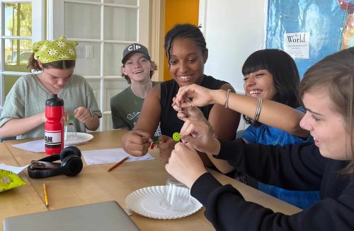 Group of kids at a table doing a project together